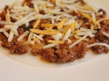 step3: 取玻璃盤子, 放一張水餃皮, 上面鋪薄薄的一層肉醬, 在鋪少許的起司絲 (** 義大利肉醬盡量取"肉餡"的部分, 醬汁不需要太多, 才不有過多的水分讓水餃皮變得太軟, 影響口感)