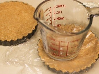 step2: 混合好的餅乾碎倒入塔盤中，利用一個平底的杯子，將餅乾碎靠緊塔盤邊緣壓實，放置一旁定型。