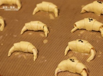 step8: 放上烤盤，表面刷少許步驟2完成的蛋液，在包有肉鬆的可頌上灑些黑芝麻點綴。