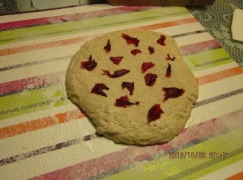 step4: 桌面灑些麵粉，將麵團取出置於桌面上，輕拍麵團擠壓部分空氣，如會黏手可灑些麵粉至不黏手為止。將台東洛神花蜜餞撕開，均勻鋪在麵團上(亦可於步驟2時加入)。