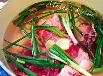 step1: 切去牛腩及牛骨上的脂肪，洗淨放入鍋中，加入1棵葱切成的葱段和2片薑片，加凍水蓋好用中大火將水煮沸然後關火。