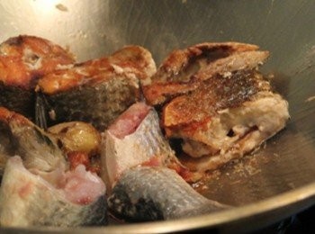 step2: 鍋內放入烏魚塊，煎香上色後加入一半的米酒煮滾。