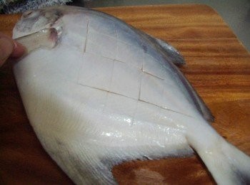 step2: 將白鯧魚去除鳃和鰭ˊ擦乾水份ˊ然後魚面劃上菱形紋ˊ再抹上少許米酒和鹽