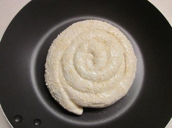 step5: 由裡捲到外呈螺旋狀,兩面抺油沾上白芝麻再稍壓平,放到平底鍋蓋鍋蓋做第2次發酵約30分鐘