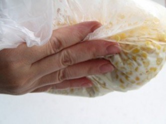 step3: 用手將材料輕揉塑膠袋，使粉類均勻的裹上玉米粒。