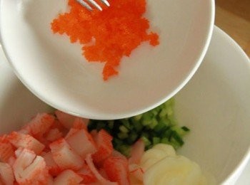 step2: 取容器放入小黃瓜丁、蟹肉棒、美乃滋、蝦卵一同拌勻。