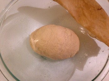 step2: 在一個大碗裡混入麵粉及鹽，加入做法一的酵母混合物。慢慢的加入約1量杯的溫水，攪拌直到可以形成球狀，並且不會過濕。將麵糰放到灑了麵粉的檯面上，揉麵糰直到表面滑順及有彈性，約2到6分鐘不等。