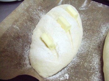 step4: 當麵團發酵至接近原來1倍大時ˊ 表面灑上少許高筋麵粉(配方份量外) 並用利的刀子沾點水於麵包表麵劃出斜線ˊ 再於斜刀線上一一擺上無鹽奶油ˊ 送入已經事先預熱的烤箱230度c烘烤18~20分鐘即可