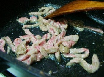 step2: 熱鍋加入油2大匙ˊ先將牛肉絲下鍋拌炒至8分熟