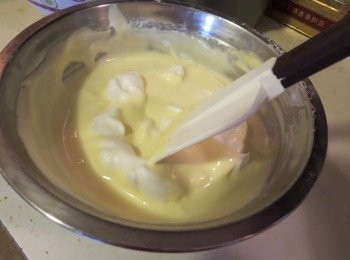 step6: 將1/3的蛋白加入至攪拌好的蛋黃糊中，用刮刀撈起底部的麵糊，從下往上翻拌至均勻 ，然後將蛋黃糊倒回剩下的蛋白中翻拌均勻（混合蛋白糊和蛋黄糊的时候先用刮刀沿容器周围刮一圈，然后将底部的面糊捞起从上往下落下（也就是把刮刀翻过来），加入Z字形切拌（用刮刀侧面划Z字线）手法，切拌次数不要太多，尽量以轻盈快速拌匀为目的）