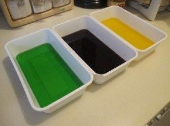 step1: 首先將3盒啫喱粉分吃倒入三個容器入,各加入4g 魚膠粉及250g熱水, 分別攪匀至完全溶解,稍涼後放入雪櫃雪四小時或以上至凝固.              三色啫喱凝固後,切成不規則的小粒,平均分佈在膠盒上.