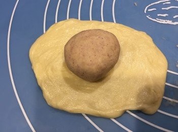 step5: 將油皮壓平，將油酥球放在已壓好的油皮上。