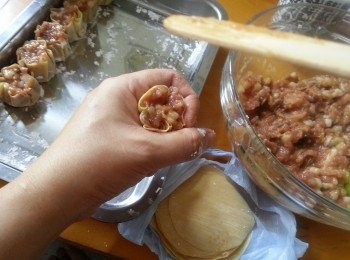 step6: 將一塊燒賣皮加入適當餡料,用手指摺合,再放於手指頭與食指中打轉,將皮面壓實豬肉