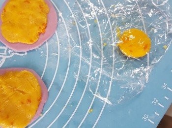 step7: 取約5g奶黃餡,用保鮮紙夾奶黃於中間,壓成圓形,然後舖在餅皮上