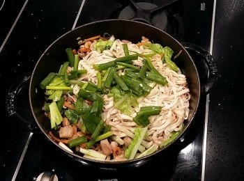 step8: 再將小白菜葉及油麵下鍋拌炒,加入鹽及水(香菇水),可用筷子來拌炒麵條比較不會結塊,醬汁及麵條容易均勻入味,最後加入蔥段拌炒。