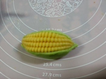 step12: 再將兩粒綠色葉搓成長形,舖在粟米左右兩邊