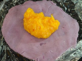 step8: 取適量的紫薯麵糰，揉成圓球再壓扁約0.5 cm 厚，然後包入適量的南瓜餡。