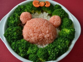 step4: 紅蘿蔔切片剪出蝴蝶結形狀，再鋪上一點點的白米飯後在放上拉拉熊的頭型。