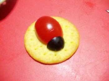 step3: 小蕃茄對切當身體ˊ黑橄欖取小部份當頭及小瓢蟲身體小黑點ˊ 生菜根當鬚ˊ<span class="group_2">褡配餡料</span>點綴當眼睛