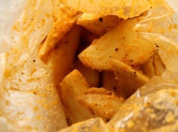 step2: 取一塑膠袋放入馬菱薯塊、辣椒粉、黑胡椒粉、鹽、起司粉、玄米油後，收緊袋口上下搖晃使調味料充份沾裹馬鈴薯。