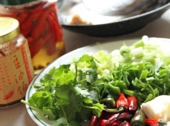 step1: 椒、泡椒、青蔥、青蒜切圓片，香菜切末備用。魚頭洗淨擦乾，放入平底鍋不需放油將魚頭內側煎香取出，蒸盤底放上薑片將魚頭放在薑片上。