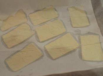 step2: 將豆腐切成薄片（約 0.3 - 0.4 mm 厚）放在廚房紙巾上，再用些許紙巾仔細吸去水分，水分越少製作出來的豆腐片就會越脆。