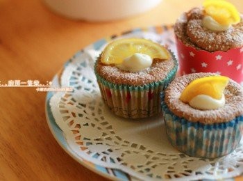 step14: [組合]: 以細長的圓型擠花嘴+擠花袋，將<span class="group_3">檸檬奶油餡</span>擠入放涼的北海道戚風巧克力杯子蛋糕中，表面放上蜂蜜漬檸檬片(可省略)、灑上一點細糖粉裝飾即可。