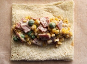 step3: 土司用桿麵棍壓平去土司邊，包入培根與玉米餡捲起土司並用牙籤將接縫處固定。