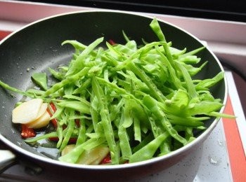 step7: 接著放入豌豆絲用鍋剷撥開