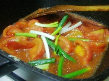 step5: 接著加入天然蕃茄醬3大匙和糖1大匙及酌量的水煮滾ˊ 然後擺入蔥段略悶