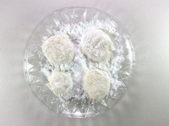 step5: 完成的麻糬放至稍微冷卻,將太白粉放入大盤子裡,麻糬分成8等份裹上一層太白粉。再將冰箱裡的紅豆泥草莓取出,雙手沾上太白粉,將每份麻糬捏成圓餅狀,包入草莓內餡即可。