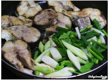 step3: 先將煎好的魚塊撥至一邊，另一邊放入蔥段及蒜片仔細炒至香味出來 讓魚塊可以吸收爆香後的香氣之後，先將魚塊盛至燒鍋