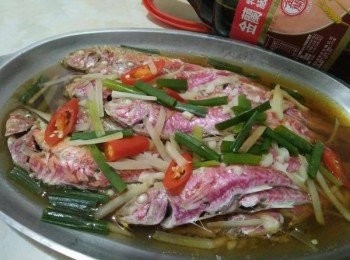 step3: 經過10分鐘後，把蒜頭放入鍋中，快接近15分鐘後，用筷子插入清蒸紅魚【澎湖野生水產】身最厚的地方，筷子若能輕鬆穿過，表示熟透了，如果還沒就多蒸2分鐘後，再試一次。