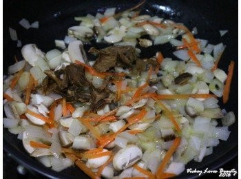 step5: 接著再放入巳事先泡軟的牛肝菌菇，紅蘿蔔絲再次拌炒均勻