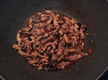 step6: 肉絲炒快熟時，放入醬油和糖熗炒上色。