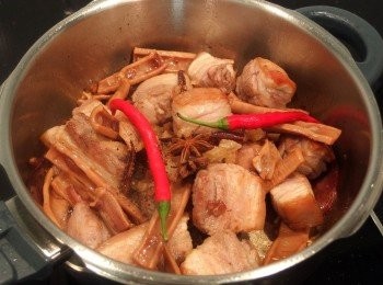 step7: 加入五花肉及辣椒翻炒,再倒入醬油及冰糖做拌炒至上色,加入米酒,煮至酒精揮發。