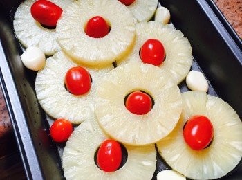 step2: 焗爐預熱180度。在深焗盤中抹上一層橄欖油。先鋪上菠蘿片，然後放入車厘茄和去皮蒜頭。