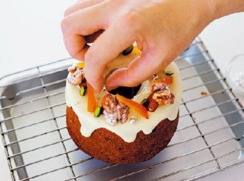 step13: 將12繞淋在11 的上面。以小濾網篩撒糖粉在核桃上，再連同其他的頂飾材料一起均衡地放在蛋糕上。