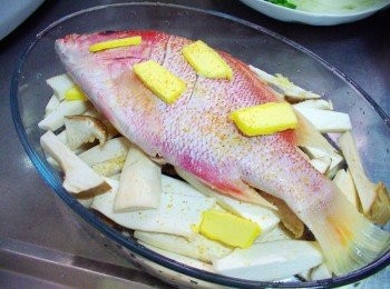 step3: 接著灑上蒜粒並於魚身再擺上奶油