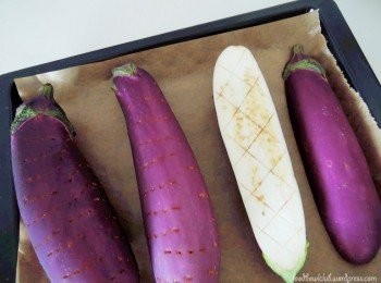 step1: 利用叉子在茄子表面戳滿小洞 。如果你喜歡，也可以切半，然後稍微在茄子麵上劃兩刀就像照片所顯示，之後再撒些鹽巴。預熱烤箱在200度，烤25-30分鐘（時間長短要看茄子的大小決定）至茄子變軟和焦。