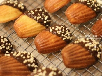 step11: <span class="group_3">巧克力杏仁角-裝飾</span>1) 將杏仁角鋪在烤盤上，進烤箱以180度C烘烤約2~3分鐘至微微上色，取出。 2) 苦甜巧克力隔水加熱融化，以<span class="group_1">馬德蓮</span>沾取少許，再灑上烤好的杏仁角，置於鐵架上待巧克力凝固。