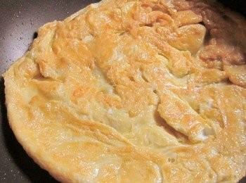 step3: 鍋中放5大匙的油,焼熱後先倒出一半的油,將作法2.蛋汁倒入,再把剛倒出的油 淋到蛋的中間,使較厚的部份快速凝結,煎到兩面金黃盛在盤子上備用