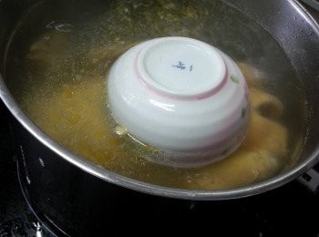 step3: 將雞放回入滾水中,蓋上蓋,中火煮10分鐘,不要開蓋熄火焗雞1小時以上,取出斬件上碟(相片是用碗壓住隻雞,目的是防止雞升起)