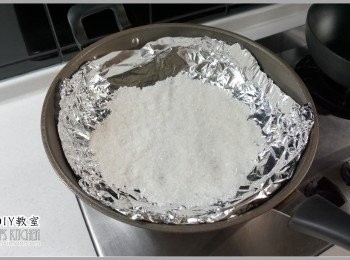 step6: 4.大炒鍋內放進一張鋁箔紙，然後把粗鹽平均鋪在上面。記得不要讓鹽巴直接接觸鍋面，不然鍋子很容易就會燒壞喔。鍋具選擇切忌使用不沾鍋，已無塗層的鍋具為佳，阿媽牌那種傳統鐵鍋最安全。