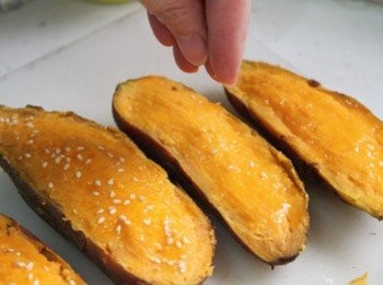 step4: 將地瓜餡填回地瓜殼中，並適當地抹平整。再將剩下1/3顆蛋黃刷上表面，最後再灑上白芝麻