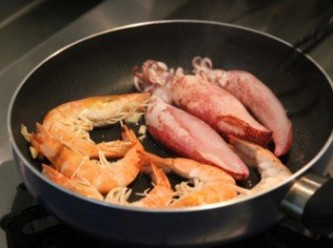 step2: 平底鍋倒少許油加熱，放入蒜末炒香，放入鮮蝦與小管小火煎香後取出。