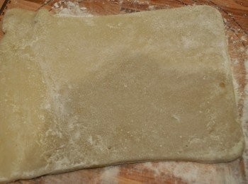 step6: 在工作台上灑下少許糕粉，將香蕉糕倒出，趁熱沾上糕粉，在表面也灑上適量糕粉，然後用麵棍將香蕉糕輾薄。（建議用保鮮膜蓋著香蕉糕才開始輾薄，這樣糕才不會黏在麵棍上。）