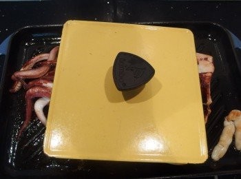 step5: 再用上蓋壓住捲曲狀的透抽,繼續煎烤。