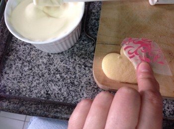 step6: 用熱水格水將朱古力座溶後塗上一層薄的朱古力漿於餅面，裁剪的朱古力移印膠片用手指將其輕於上去推平至沒氣泡