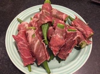 step2: 平鋪一片牛肉，將一條秋葵放在牛肉片的一端，捲著秋葵，再用牙籤串起定位。